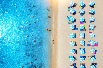 Wall Mural - aerial view of colorful umbrellas on sandy beach and blue sea
