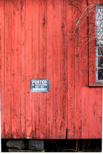 Weathered Red Wood Siding With Posted, No Trespassing Sign