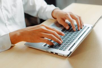 Wall Mural - businessman hand typing on computer keyboard of a laptop computer in office. business and finance co