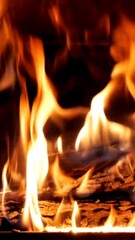 Wall Mural - Closeup slow motion vertical shot of the firewood burning in a fireplace with dark hazy background