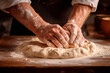 A baker's hands expertly kneading dough on a floured surface, preparing to bake bread.