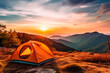 Camping tent on a hill during sunset with mountainous backdrop.