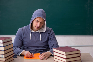 Wall Mural - Young male student sitting in the classroom