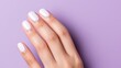 © Iuliia - Feminine well-groomed hand with stunning manicure on lilac background, nail service mockup, close-up