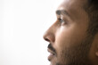 Close up profile photo of handsome serious Indian man on white gray studio background. Guy having attractive appearance, groomed beard look into distance, thoughts, ponders, memories, eyesight, vision