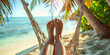 Close-up of bare feet in a hammock on a tropical beach with palm trees.