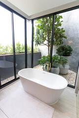 Wall Mural - Luxury bathroom with white bathtub by the window, concept in a modern house