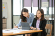 © Thitisak - Asian business woman working and talking at the office