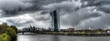 Panoramaansicht der Europäischen Zentralbank in Frankfurt am Main mit dem Fluß Main im Vordergrund bei stürmischem Gewitter und dramatischem Wolkenhimmel