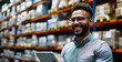 Smiling male warehouse manager using a digital tablet for inventory management in a modern storage facility, exemplifying efficient logistics and organization