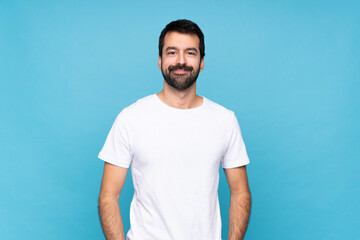 Wall Mural - Young man with beard  over isolated blue background laughing