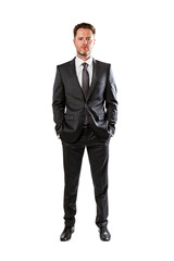 Wall Mural - Serious businessman in classic black suit, standing with hands in pockets, isolated on white. Professional look