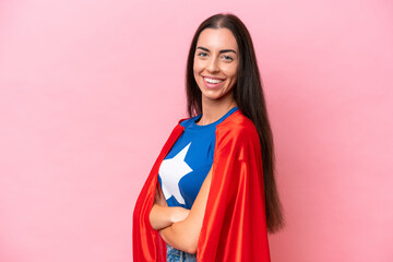 Wall Mural - Super Hero Caucasian woman isolated on pink background with arms crossed and looking forward