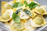 Fototapeta Mapy - Homemade Ravioli pasta with spinach and ricotta cheese filling with creamy white sauce and grated Parmesan cheese. 