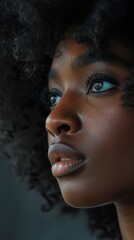 A close-up view of an African American womans face with curly hair.