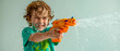© HUMANIMALS - Boy with a water pistol, child playing with a toy