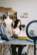 © Nuttapong punna - Asian lady blogger showing clothes in front of the camera to recording vlog video live streaming at her shop. 