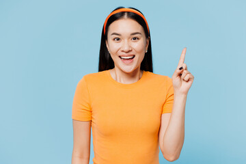 Wall Mural - Young proactive woman of Asian ethnicity wear orange t-shirt casual clothes holding index finger up with great new idea isolated on plain pastel blue cyan background studio portrait Lifestyle concept