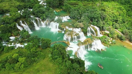 Wall Mural - The beautiful Ban Gioc waterfalls on the border with China with tourist boats , Asia, North Vietnam, Cao Bang, towards Lang Son, in summer on a sunny day.