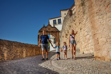 Wall Mural - Parents with two kids have a walk in old part of Ronda, Spain