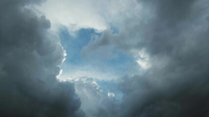 Wall Mural - Dark storm clouds moving and the hole with a piece of blue sky, timelapse 4k