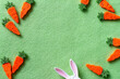 Composition with cute carrots and bunny ears on green background, easter concept