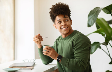 Wall Mural - Stylish african american guy drinking cappuccino while working at cafe