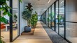© Togrul - The image shows a modern office interior with a long corridor. The corridor is decorated with plants and has large windows that let in natural light.