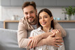 © Prostock-studio - Happy couple embracing on the sofa and smiling at camera