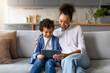 © Prostock-studio - Black mother and son enjoying time together with tablet
