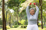 Fototapeta  - asian elderly woman exercising and lifting dumbbells in the park