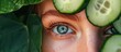 A close-up view of a persons face with cucumber slices placed around the eyes, as part of a rejuvenating eye treatment. The cucumbers are known for their soothing and refreshing properties, helping to