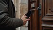 © CinimaticWorks - businessman using mobile device, smartphone application for digital security, remotely managing house and office door operations