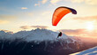 Skydiver flying over snow mountains during sunset 