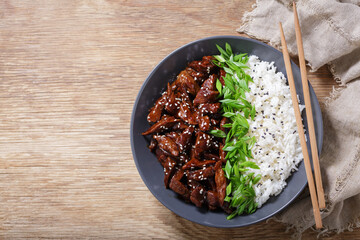 Wall Mural - plate of  teriyaki beef, rice, green onion and sesame seeds, top view