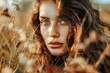 Portrait of a young woman with freckles, captured in the warm golden hour sunlight with soft focus on grass