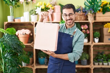 Poster - Handsome hispanic man working at florist shop winking looking at the camera with sexy expression, cheerful and happy face.