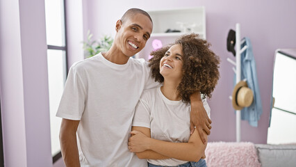 Wall Mural - Confident, beautiful couple hugging and smiling in their cozy home, embracing their love and happiness together