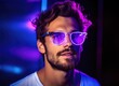 © Marharyta - Man with glasses standing in front of purple light.