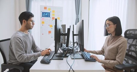 Young adult Asian male, female software developer coding program on desktop computer. Man, woman work from home, remote working, freelance programmer job, smart digital nomad lifestyle concept