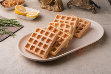 Two Viennese waffles on a beige dish on a table