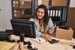 © Krakenimages.com - Young beautiful plus size woman ecommerce business worker counting dollars using calculator at office