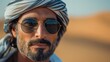 © natalikp - Portrait of a handsome Arabian man with sunglasses in the desert