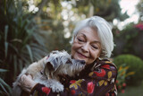 Happy eldery woman with grey hair with embracing her cute pet dog 