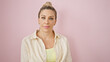 © Krakenimages.com - Young blonde woman standing with serious expression over isolated pink background