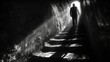 Silhouette of a man walking up the stairs in a dark underground tunnel