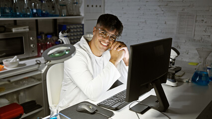 Poster - Young hispanic man scientist using computer smiling at laboratory