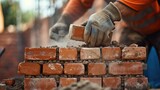 Fototapeta Panele - A bricklayer constructs a stone wall using wood, metal tools, and building materials like bricks and rocks. AIG41