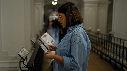 Wall Mural - Young beautiful hispanic woman visiting crypt reading brochure at Imperial Crypt in Vienna