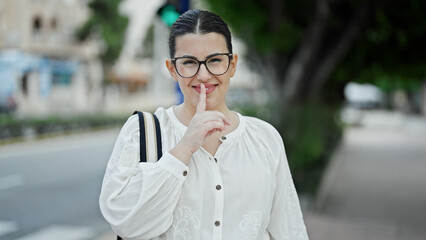 Wall Mural - Young beautiful hispanic woman woman smiling asking for silence at street